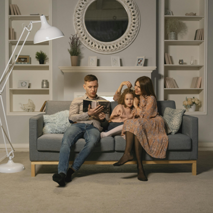Family sitting on couch ready a book