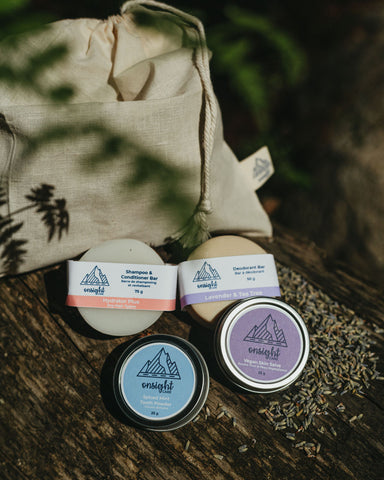 Liquid Free Travel Bundle including cotton bag, shampoo & conditioner bar, tooth powder, vegan skin salve, and deodorant bar shaded by greenery