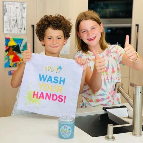 Kids holding WASH YOUR HANDS Handy Towel. SPLATZ fun!