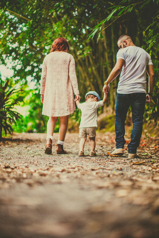 Parents walking with a young child in the woods