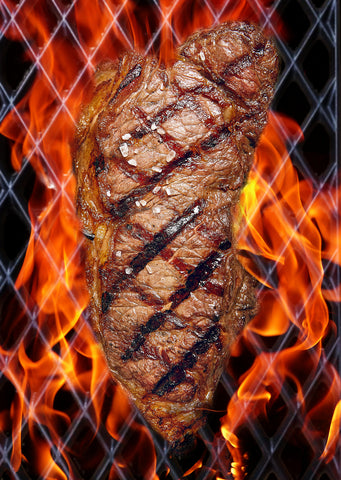 Steak on a Trivantage Grill with flames 