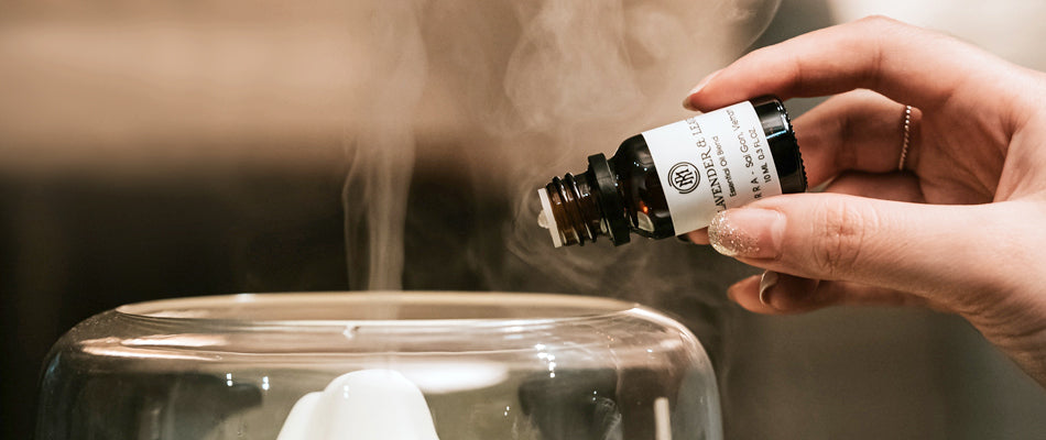 Close-up of someone adding essential oils to a diffuser.