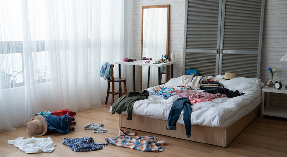 A messy, cluttered bedroom scene.