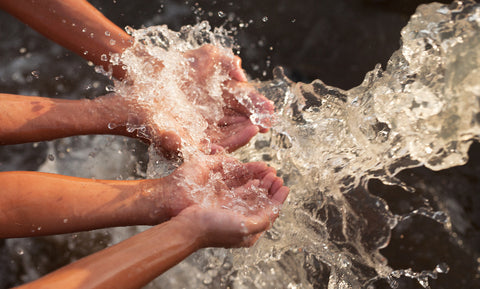 Four hands getting splashed with clean water