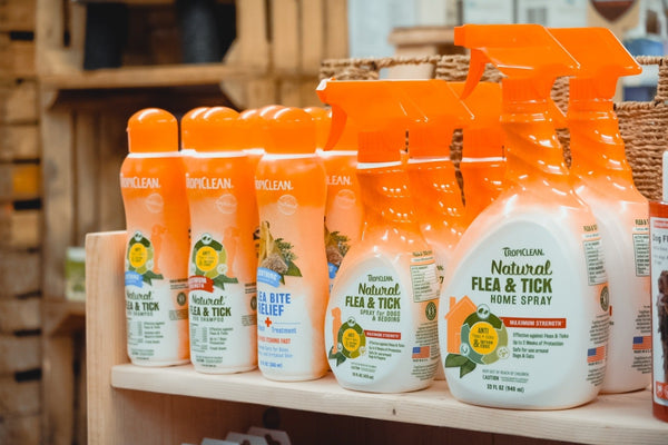 Bottles of Tropiclean products displayed on a wooden shelf