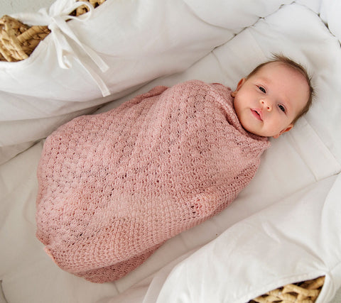 Baby in a pink merino swaddle