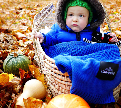 Baby in a blue bamboo blanket in Autumn