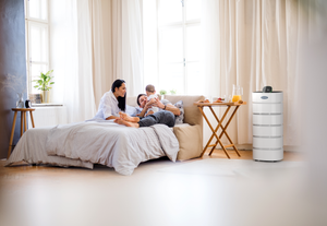 family with baby in bedroom with Carrier air purifier XL