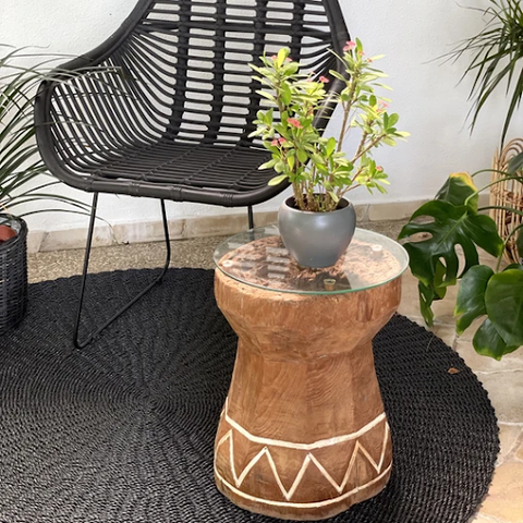The Indian Coffee Table with a potted plant and positioned near a chair
