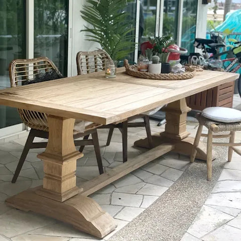 The Rustic Teak Dinning Table positioned in a yard