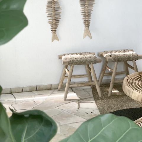 Two Cyprus Stools beside a white wall with bohemian decor