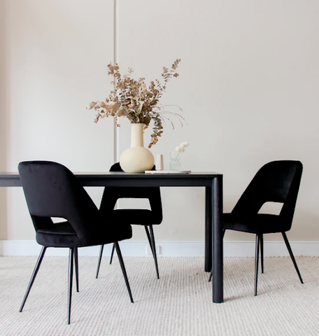 A black dining table with black chairs
