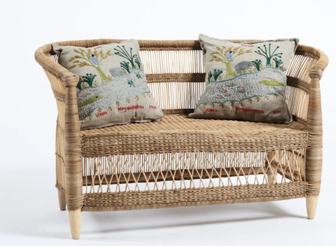 A two-seated natural rattan chair with two pillows