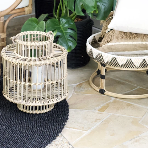  A small rattan lamp shade on a black carpet beside a small table