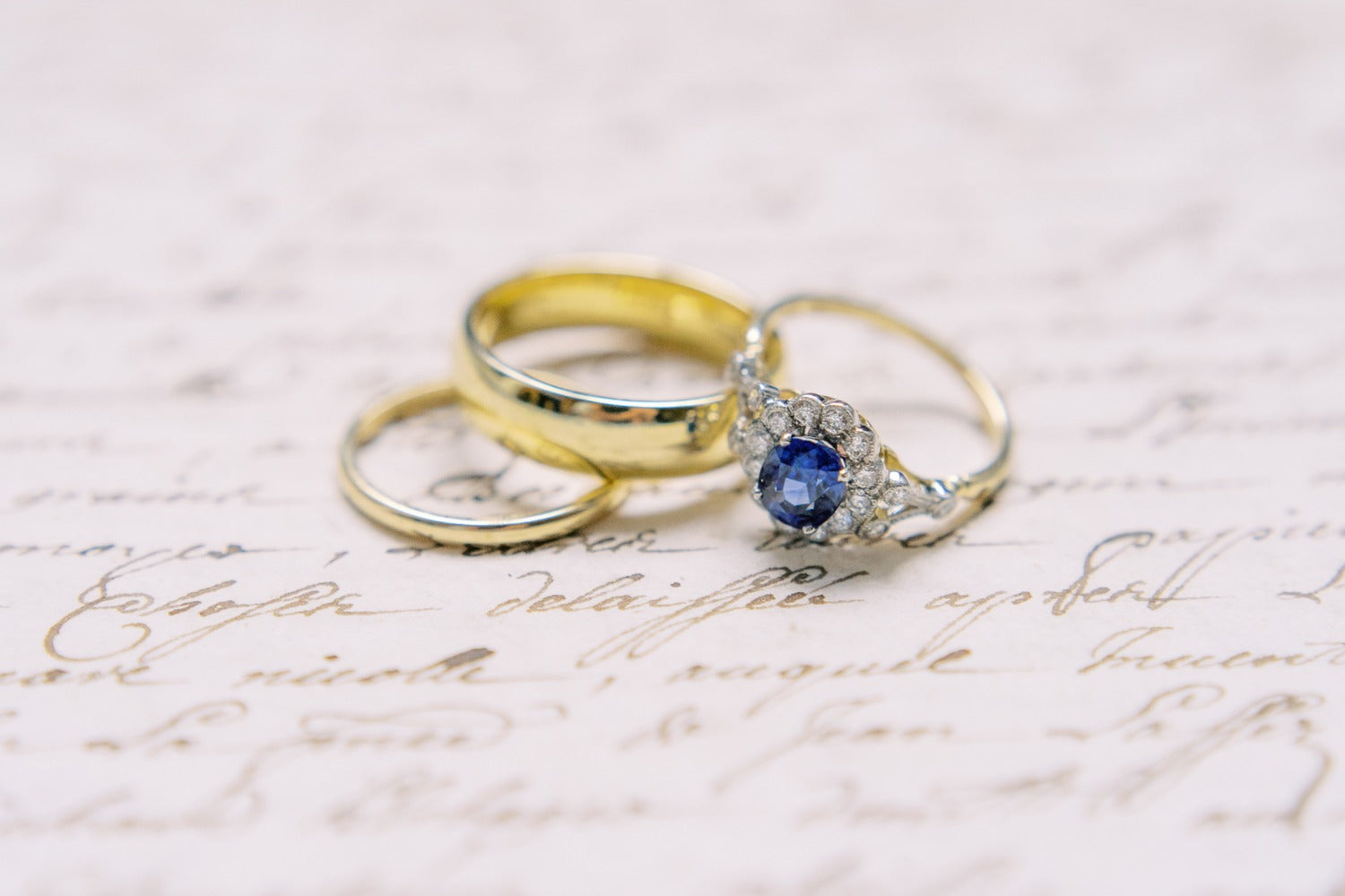 Sapphire and diamond flower ring with yellow gold wedding rings