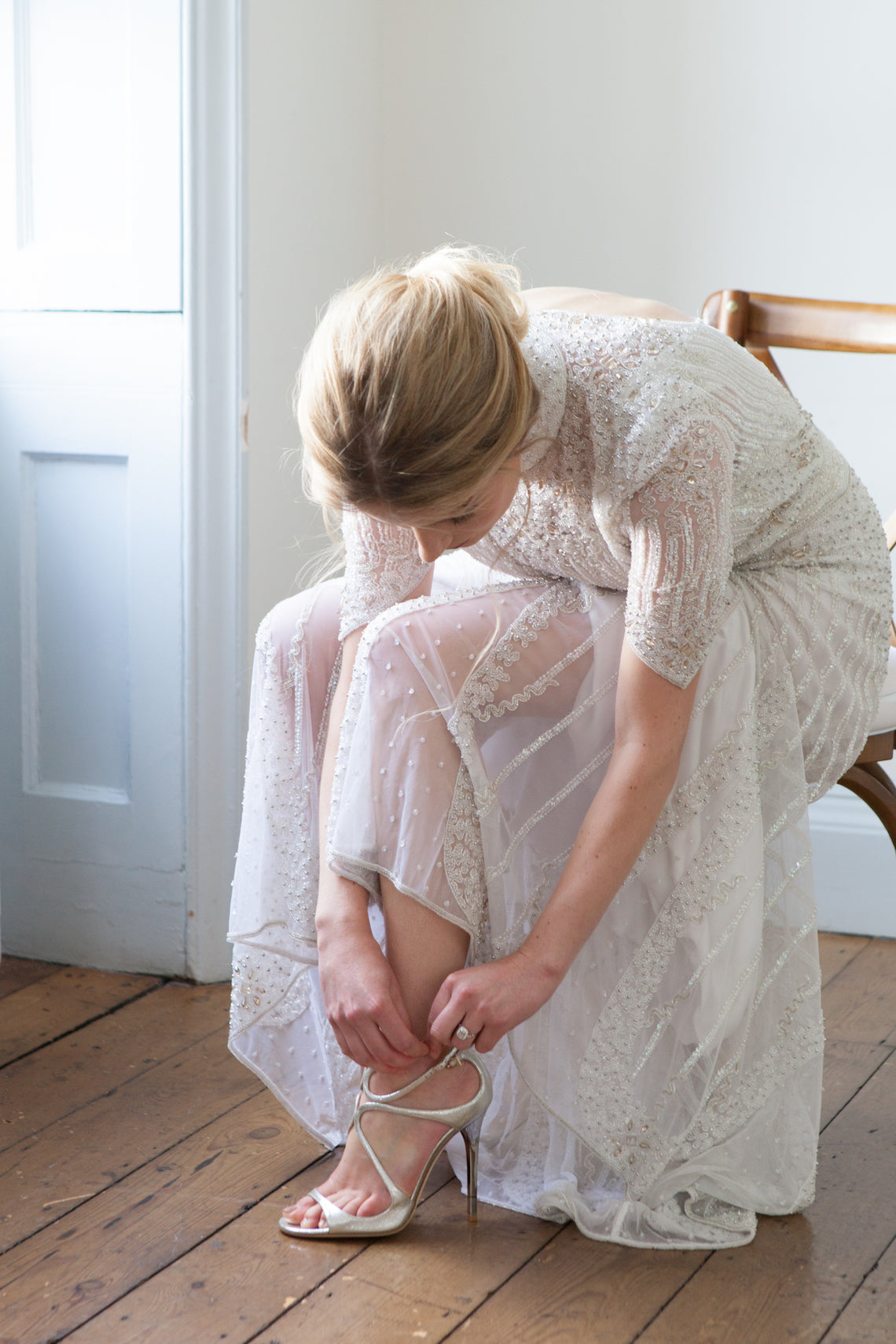 Bride wears halo cluster emerald cut diamond engagement ring