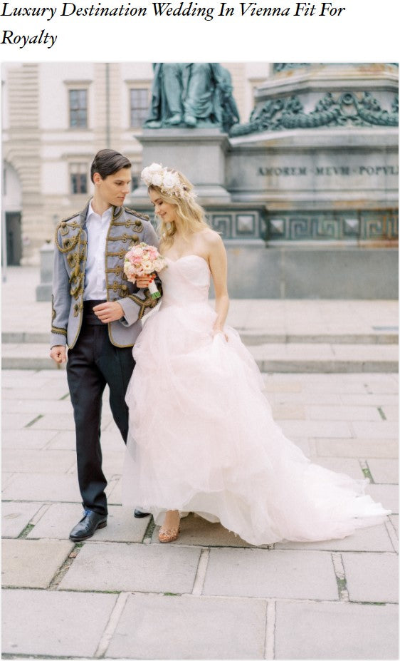 Couple in wedding outfits walking along a Vienna street