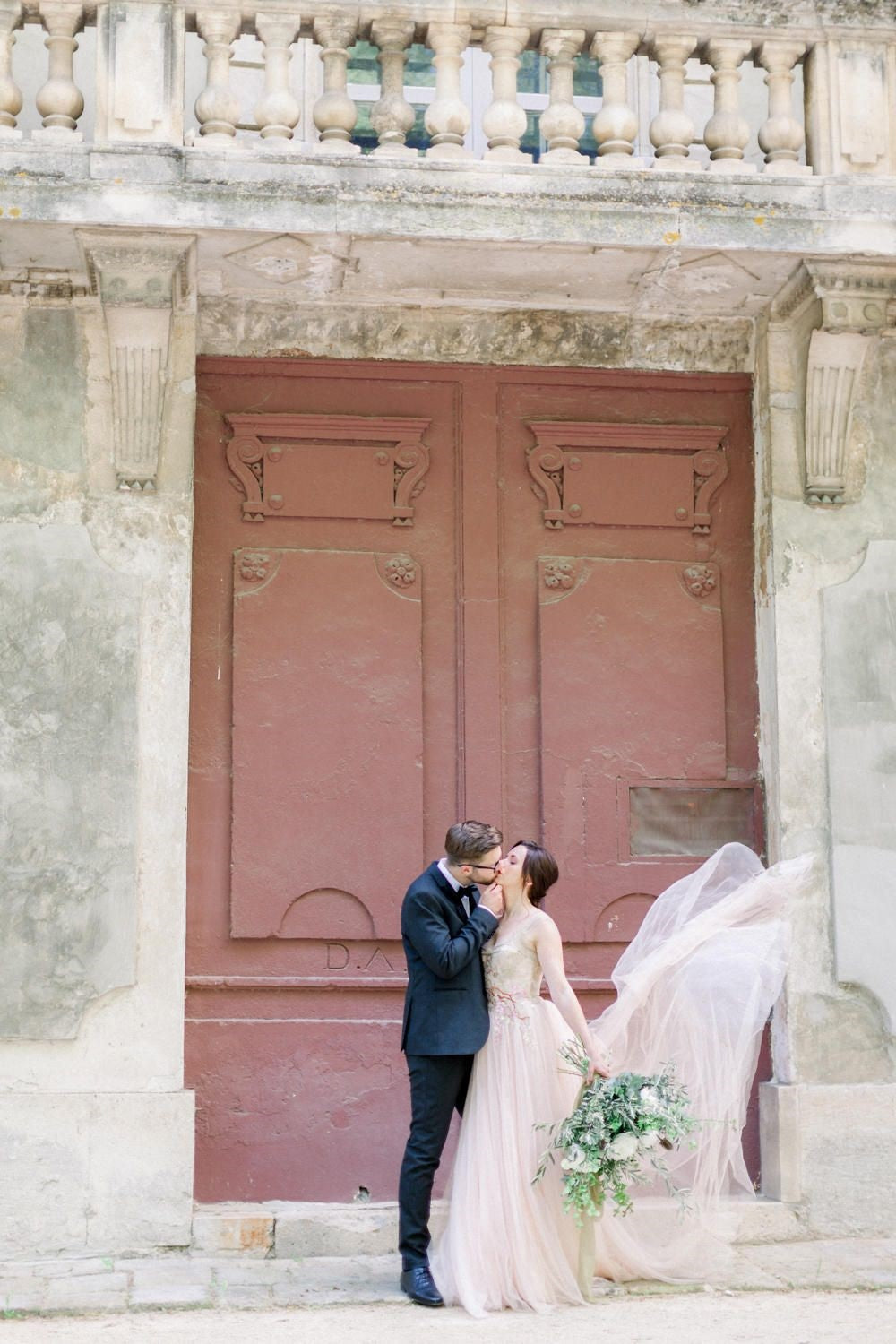 Bride and groom outside red door