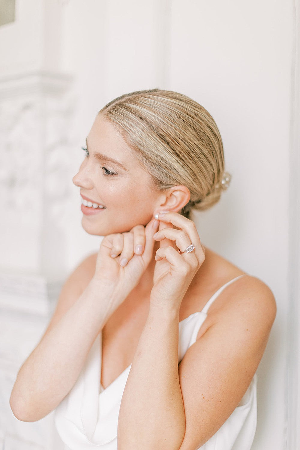 Bride wearing three stone emerald cut diamond engagement ring