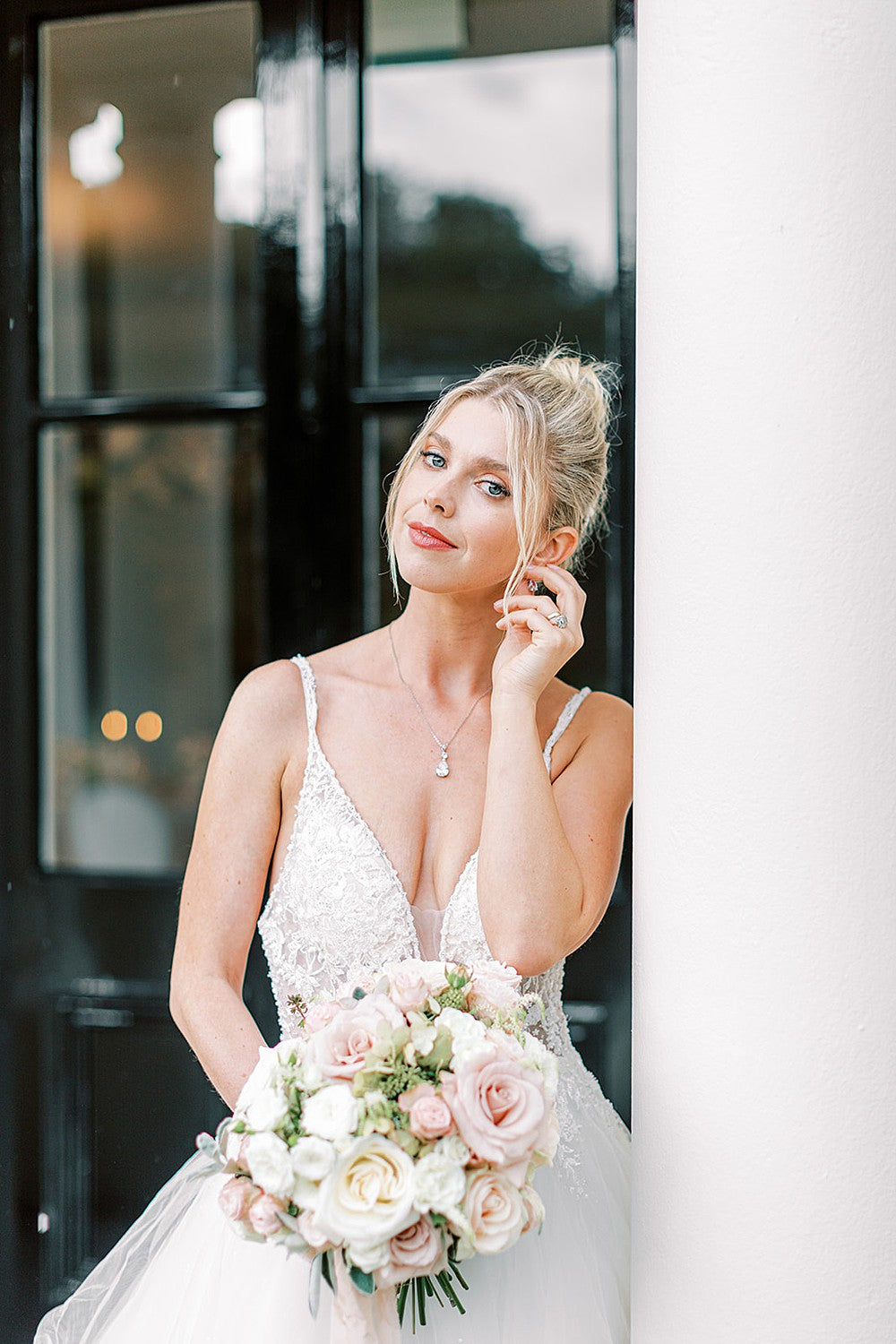 Bride wears earrings to match diamond engagement ring and plain wedding band