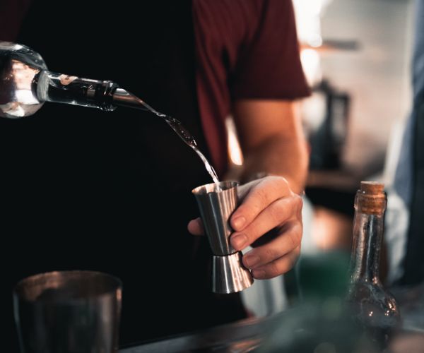 Bartender pouring liquor in a jigger