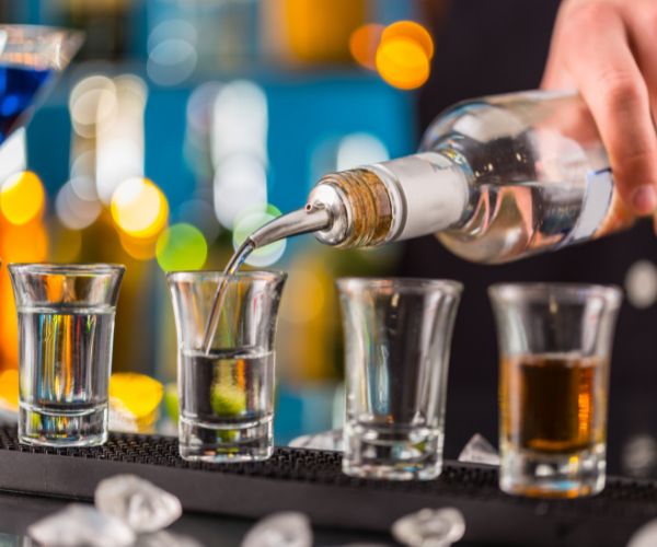 Metal pourer in liquor bottle, pouring drinks in shot glass