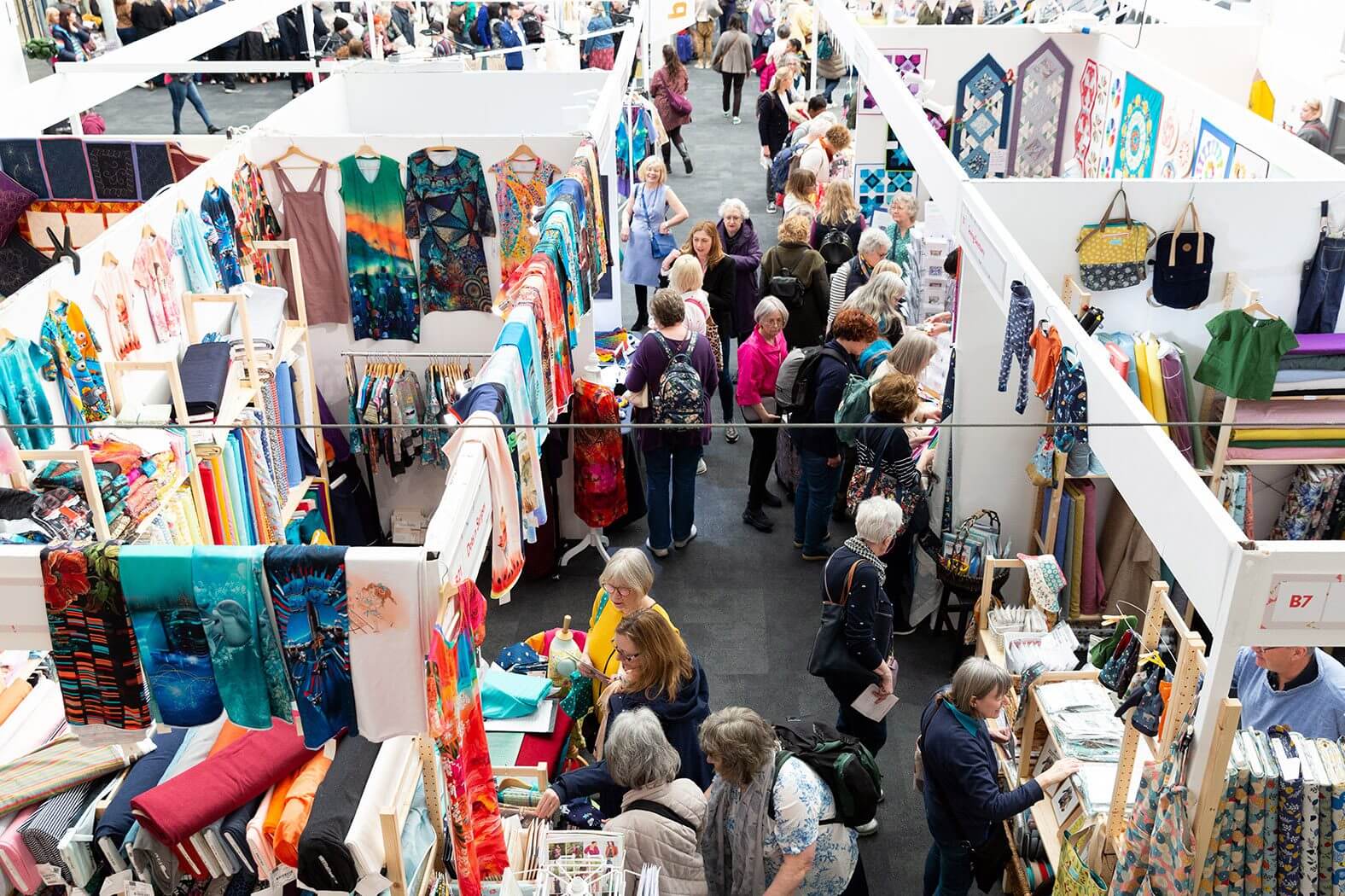 Photo of booths at The Stitch Festival from above, with colourful displays of fabrics and clothes