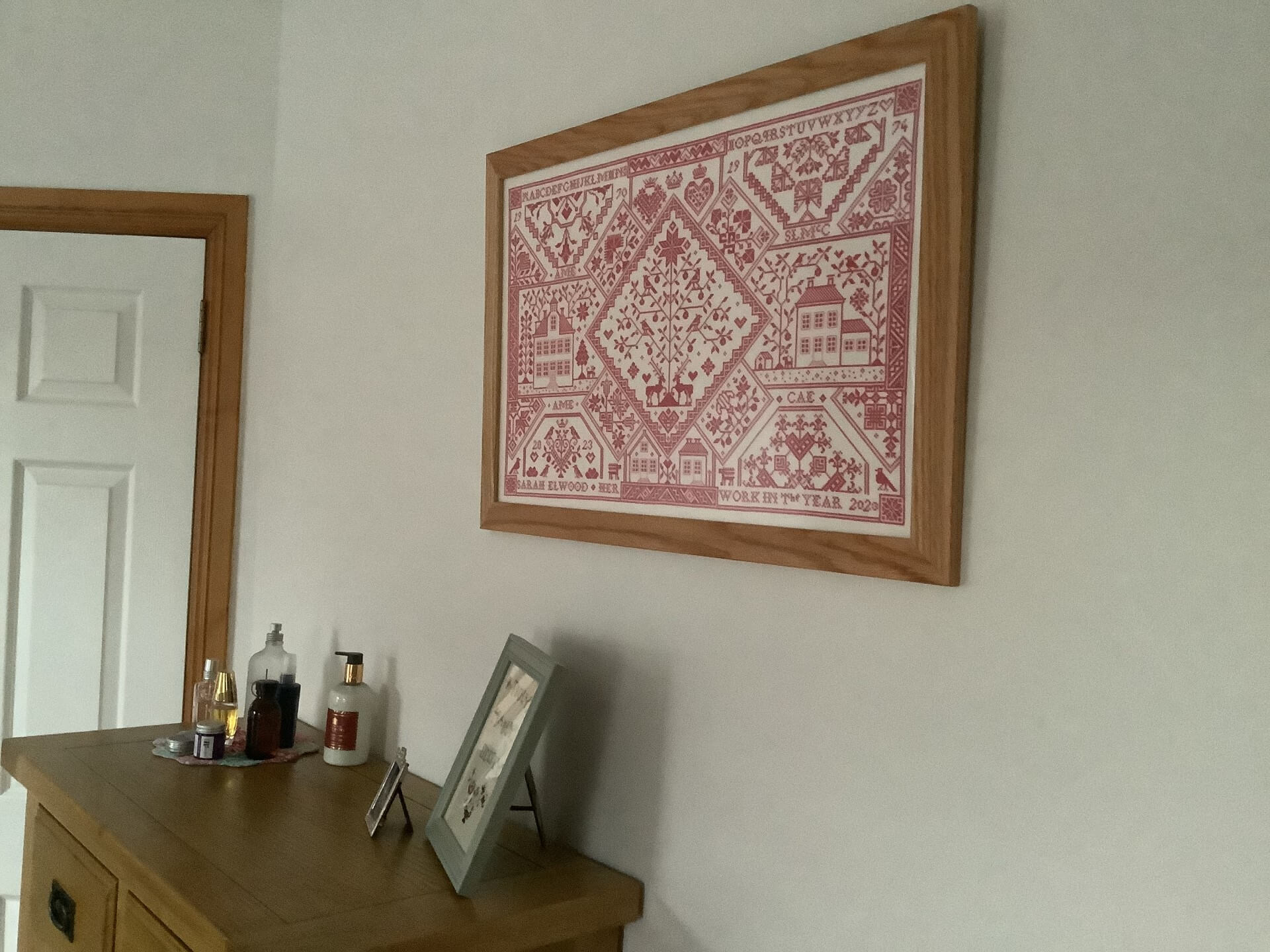 Sarah Elwood's A Family Patchwork Sampler by Modern Folk Embroidery hanging in wooden frame