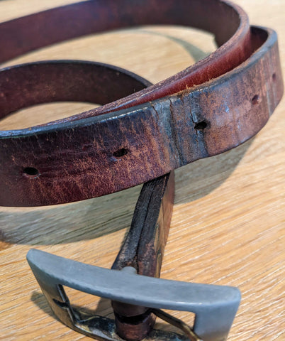 Frame buckle showing stressed leather belt strap