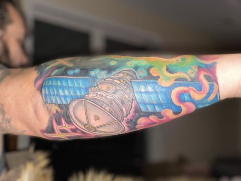 a satellite tattoo on an arm