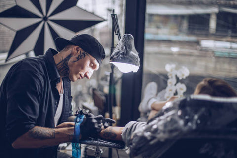 tattoo artist working on a client