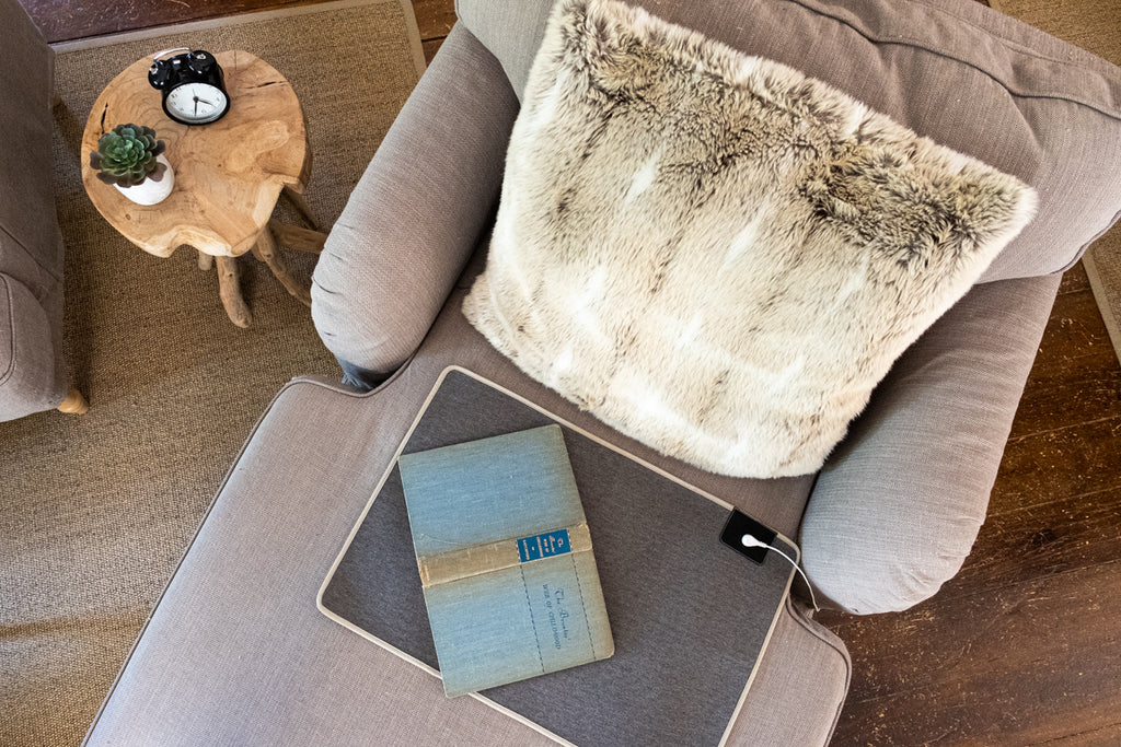 earthing pad plugged in resting on chair grey color