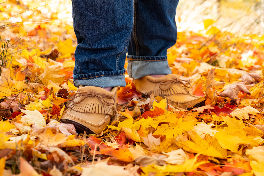 earthing wearing moccasins on bright yellow leaves in the fall