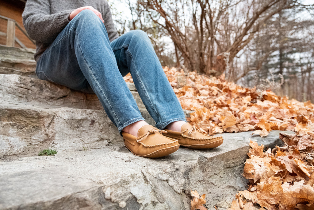 Sitting on stones in the fall wearing casual relaxed and stylish moccasins