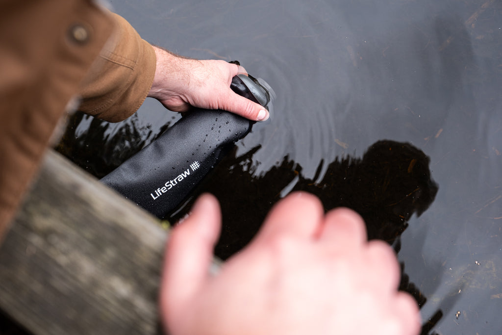 Getting water from a lake using lifestraw collapsible water bottles