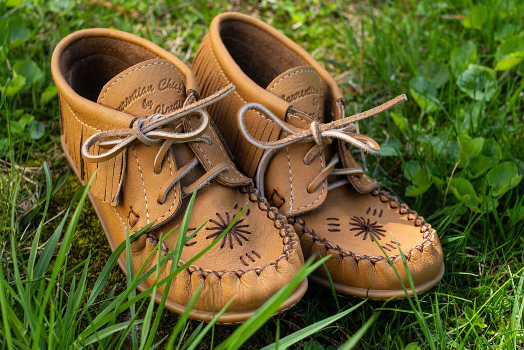 These are a beautiful pair of leather moccasins with a fringe and hand-embroider design on the vamp made in Canada.