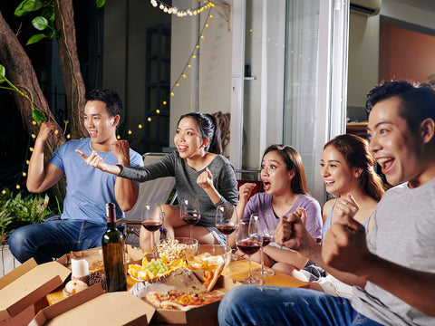 a-group-of-five-person-was-enjoying-party-dinner-while-cheering-out-loud-on-a-show-they-watching