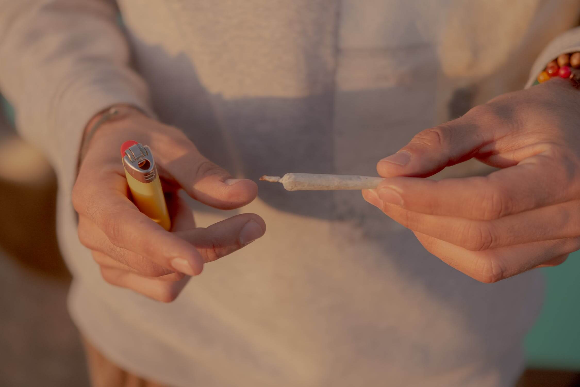 Person holding a joint and lighter