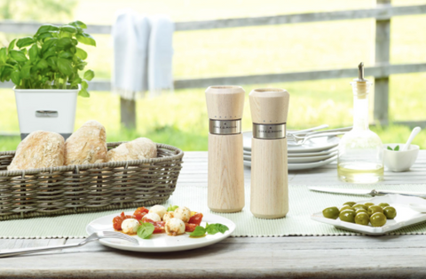 salt and pepper mills on table with food