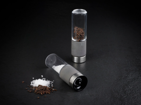 salt and pepper mills on black background