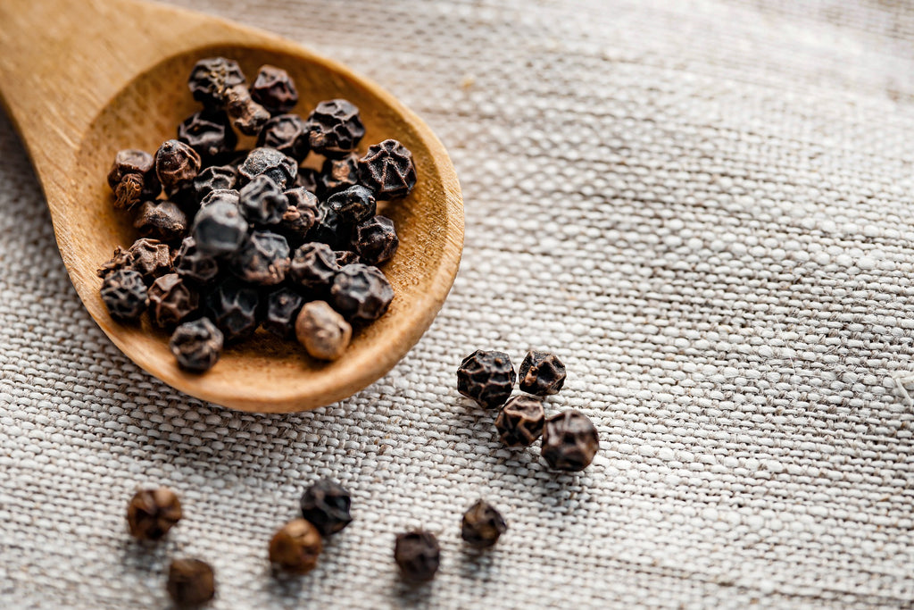 peppercorns on a wooden spoon 