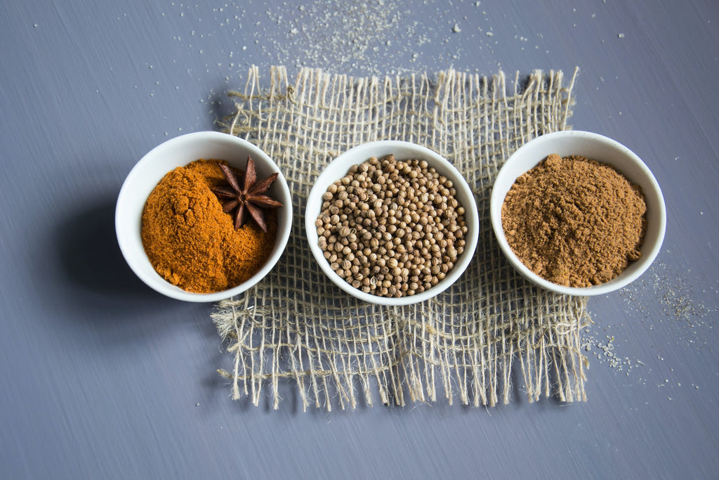 spices stored in small open white bowls