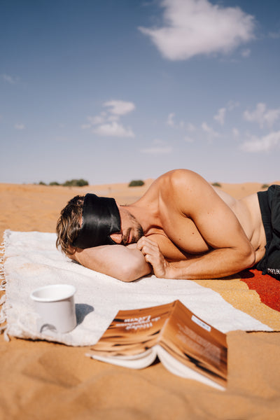 Man with an eye mask in the desert.