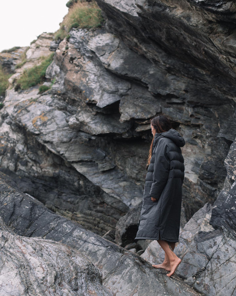 Woman walks in Changing Robe on rocks