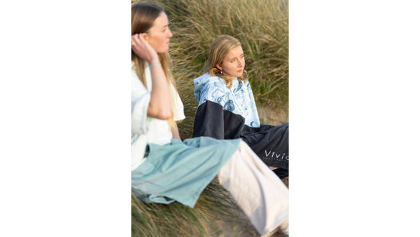 Teenage girls wearing poncho towels on the beach - Vivida Lifestyle