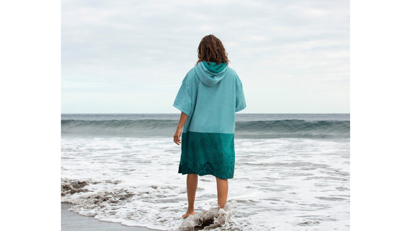 Woman swimmer in sea wearing a poncho towel changing robe