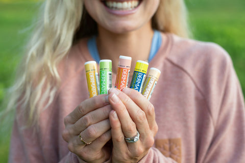 Jessie Diggins holding all 5 Dermatone lip balm flavors