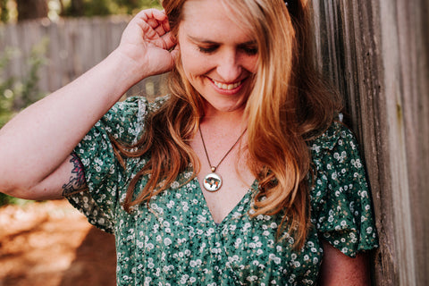 Woman in a green floral dress wearing floral bison pendant necklace