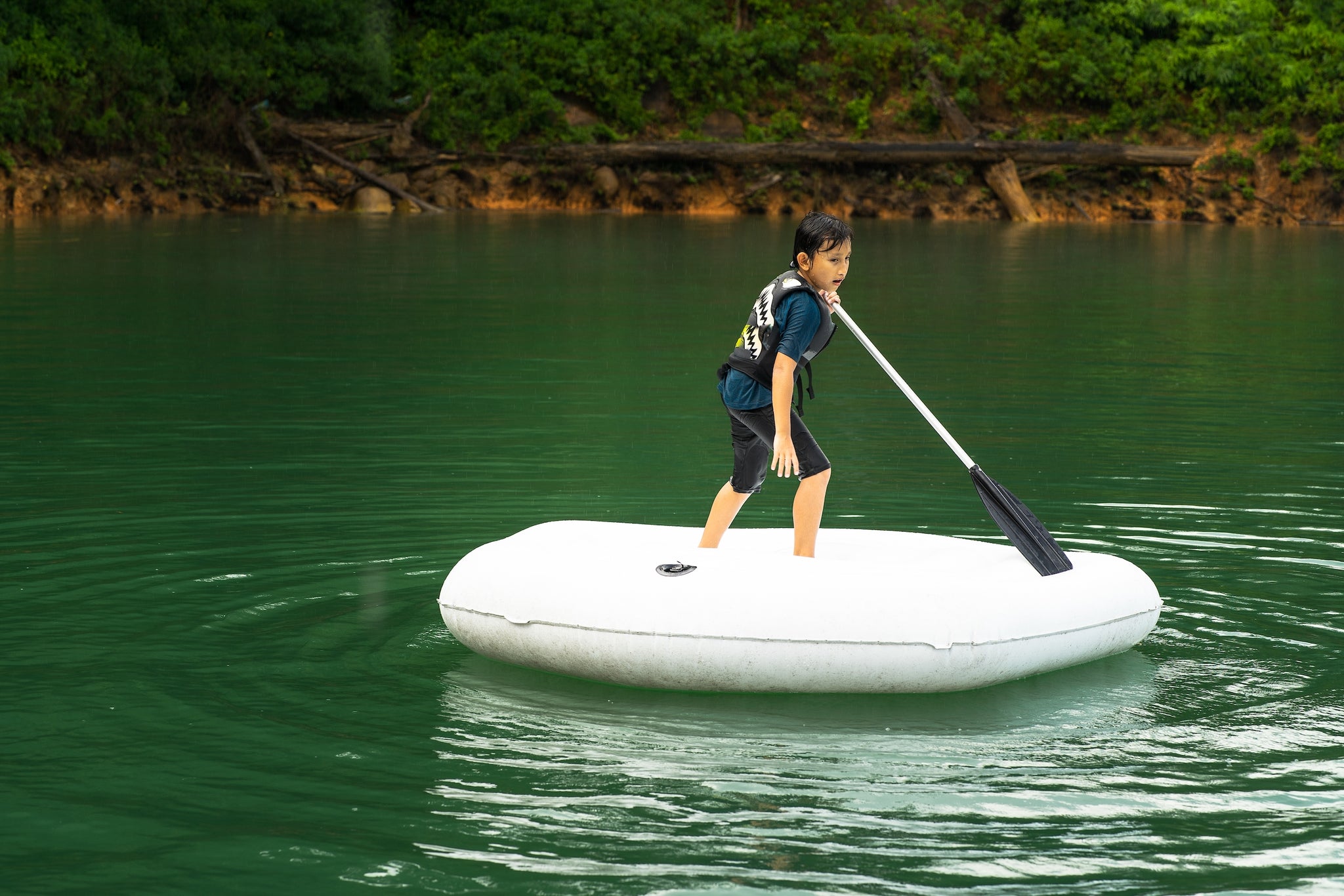 boy on white inflatable paddle board