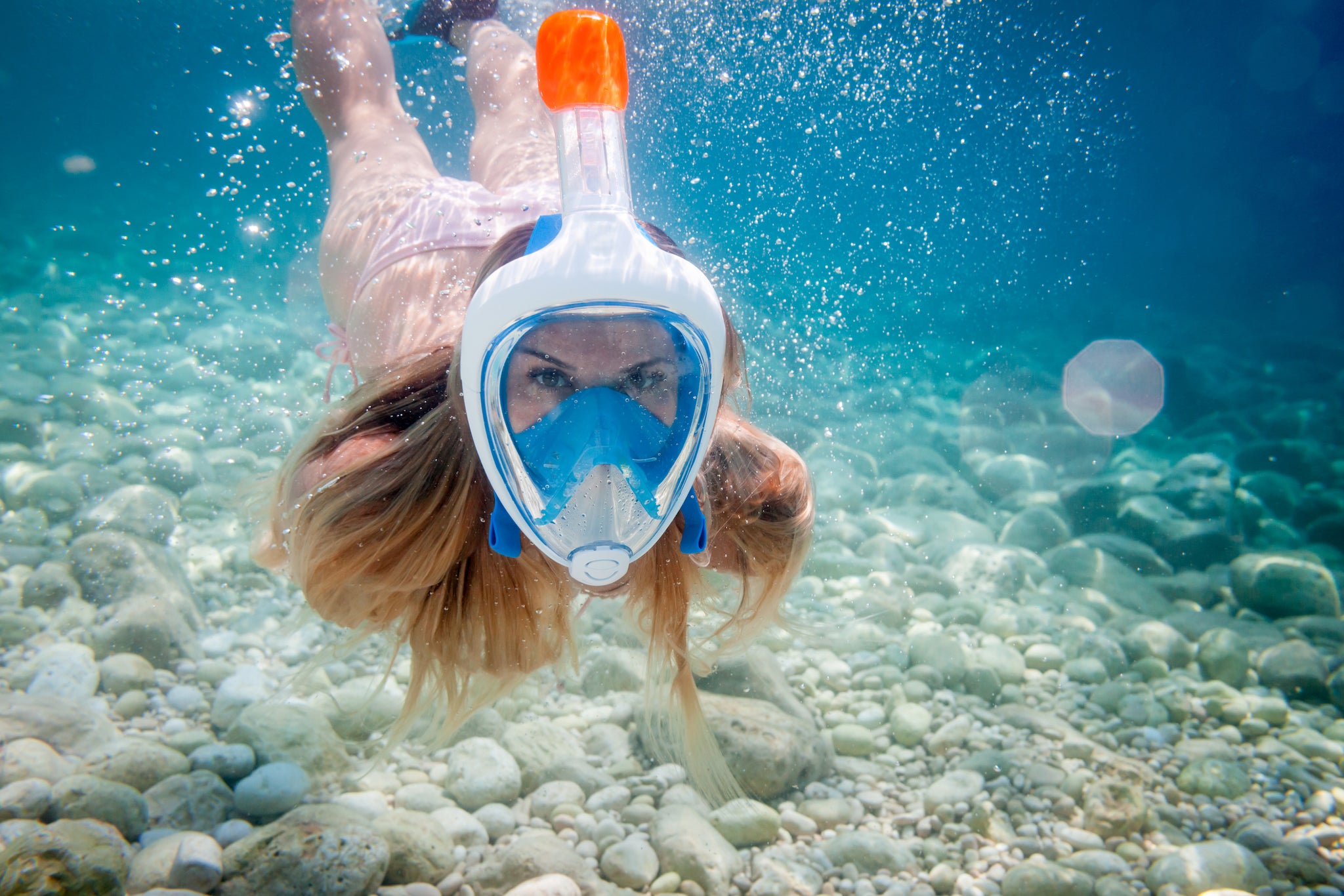 woman underwater wearing full face mask